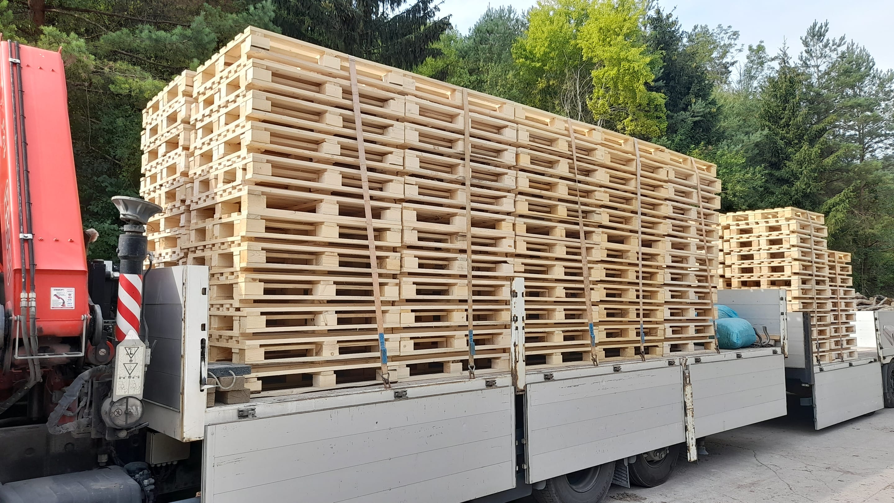 Nákladní auto s hydraulickou rukou naložené paletami